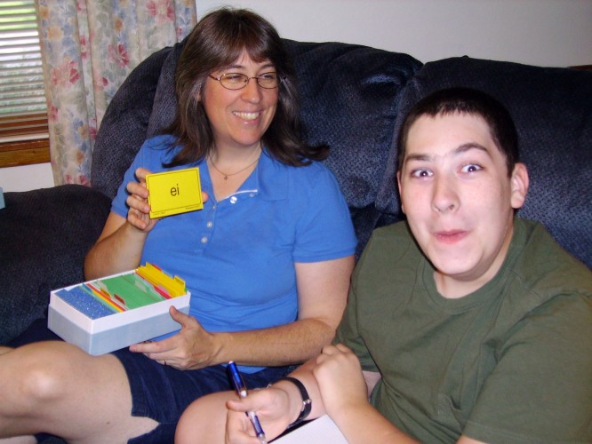 Happy mother reviewing phonogram cards with son