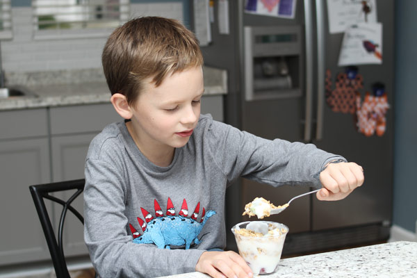 Young boy eating yogurt parfait