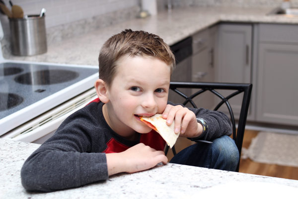 Child enjoying pizza tortilla snack