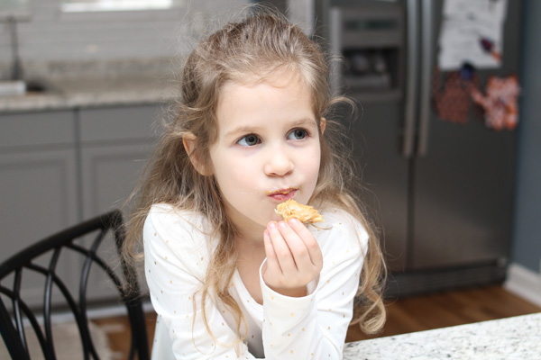 Happy preschooler enjoying peanut butter waffle snack