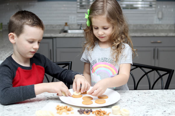 Preschool girl and boy assembling ABC snack