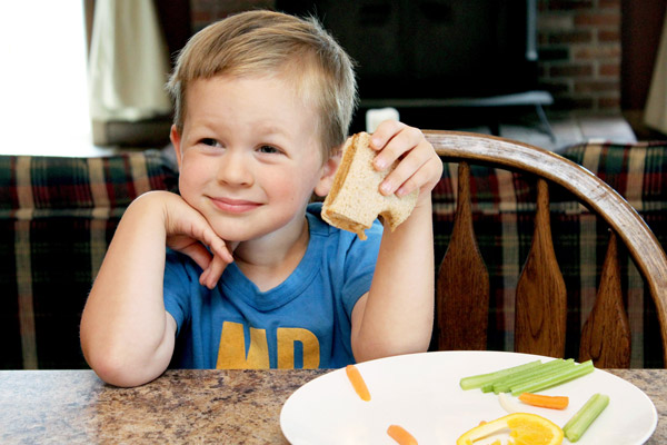Young boy eating sandwich