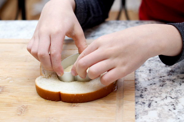 Boy cutting heart shape into bread
