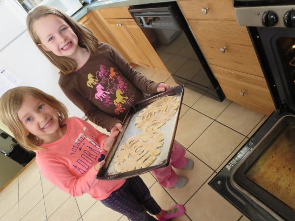 Smiling girls baking tortillas