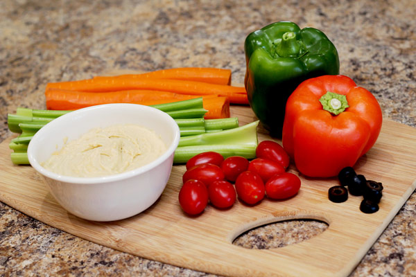 Vegetables and hummus on cutting board