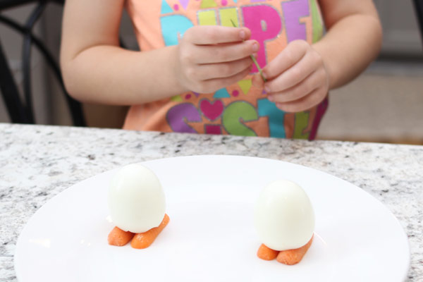 Child adding feet to hard-boiled egg
