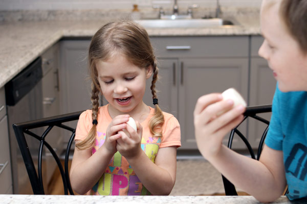 Young girl and young boy enjoying hard-boiled egg snack