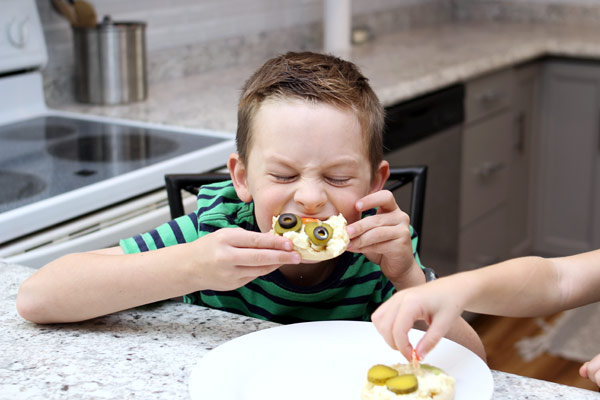 Little boy enjoying egg salad sandwich