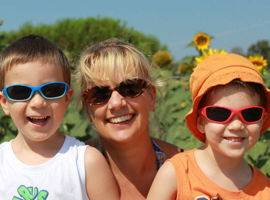 Mother and kids outside smiling in sunglasses