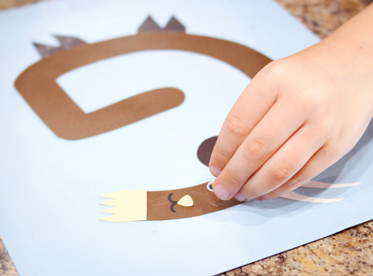 child adding a googly eye to her letter G craft