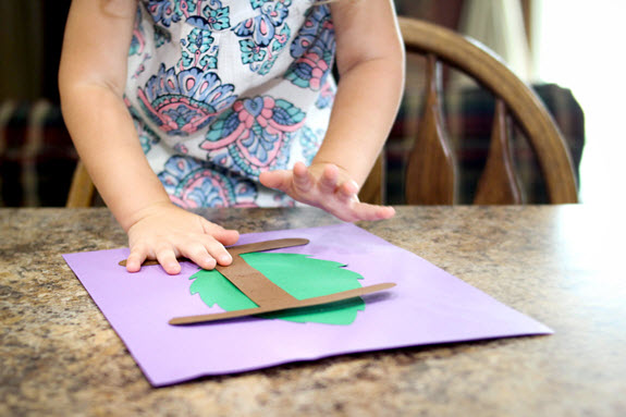 child gluing her letter i craft