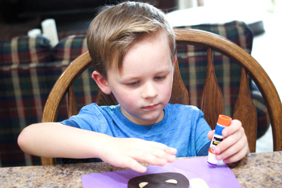 boy assembling his letter m craft