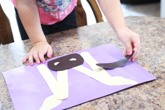 child putting a tusk on her letter m craft
