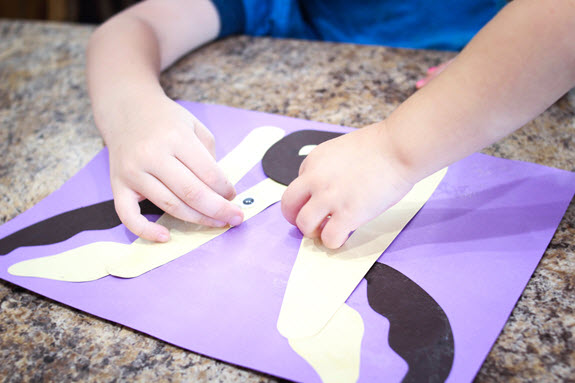 children gluing eyes on their letter m craft