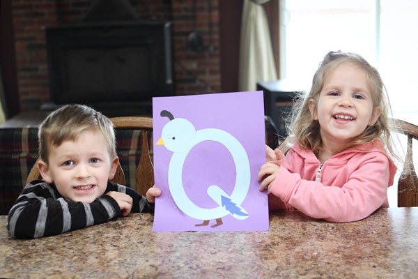 smiling children with their completed letter q craft