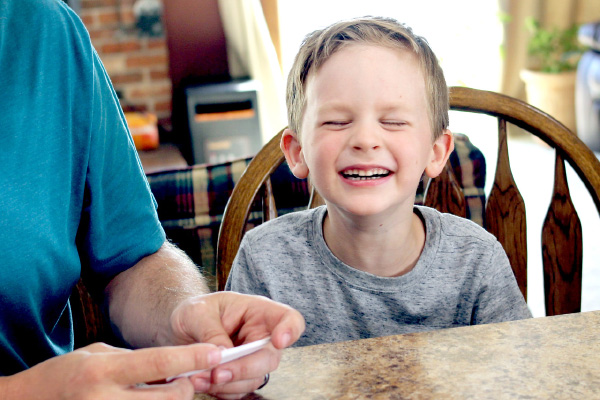 Boy laughing at answer in mashed potatoes listening game