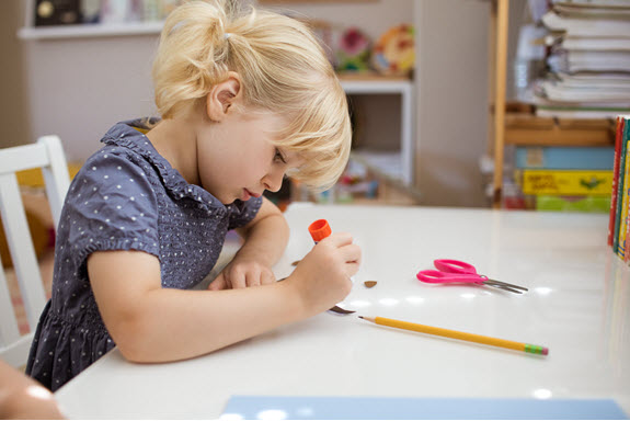 child glues her lowercase h craft