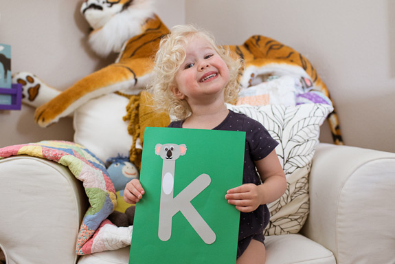 little girl displays her finished lowercase k craft