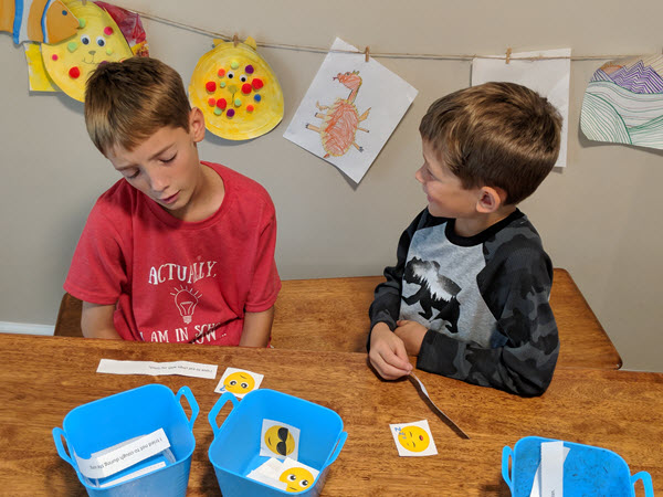 two boys play with fun with emojis activity