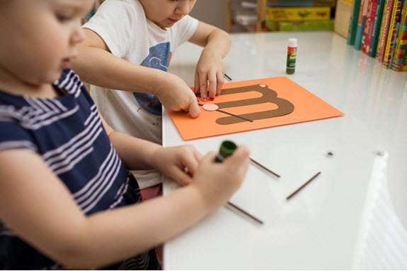 children glue whiskers to their uppercase letter M craft