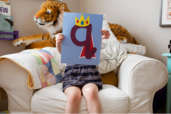 child holds up her lowercase q craft