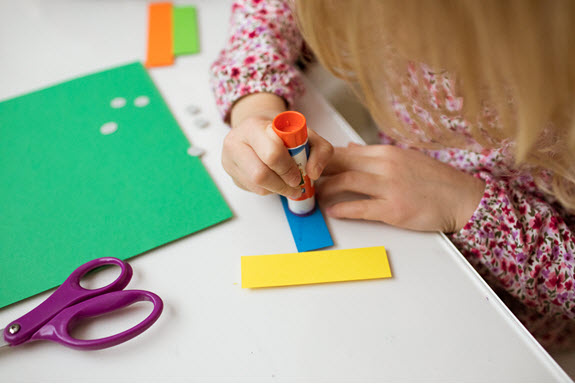 child glues her lowercase x craft