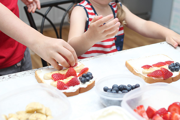 Children assembling fruity flag independence day snack