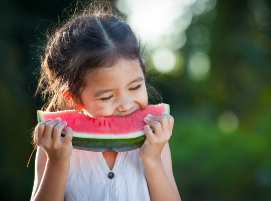 girl eats a piece of watermelon