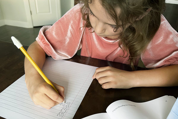 Girl writing with pencil and paper