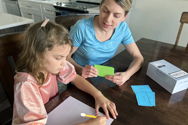 woman teaching girl with word cards