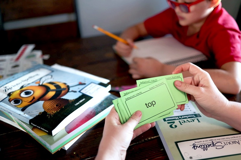 Children using flashcards and other All About Spelling materials