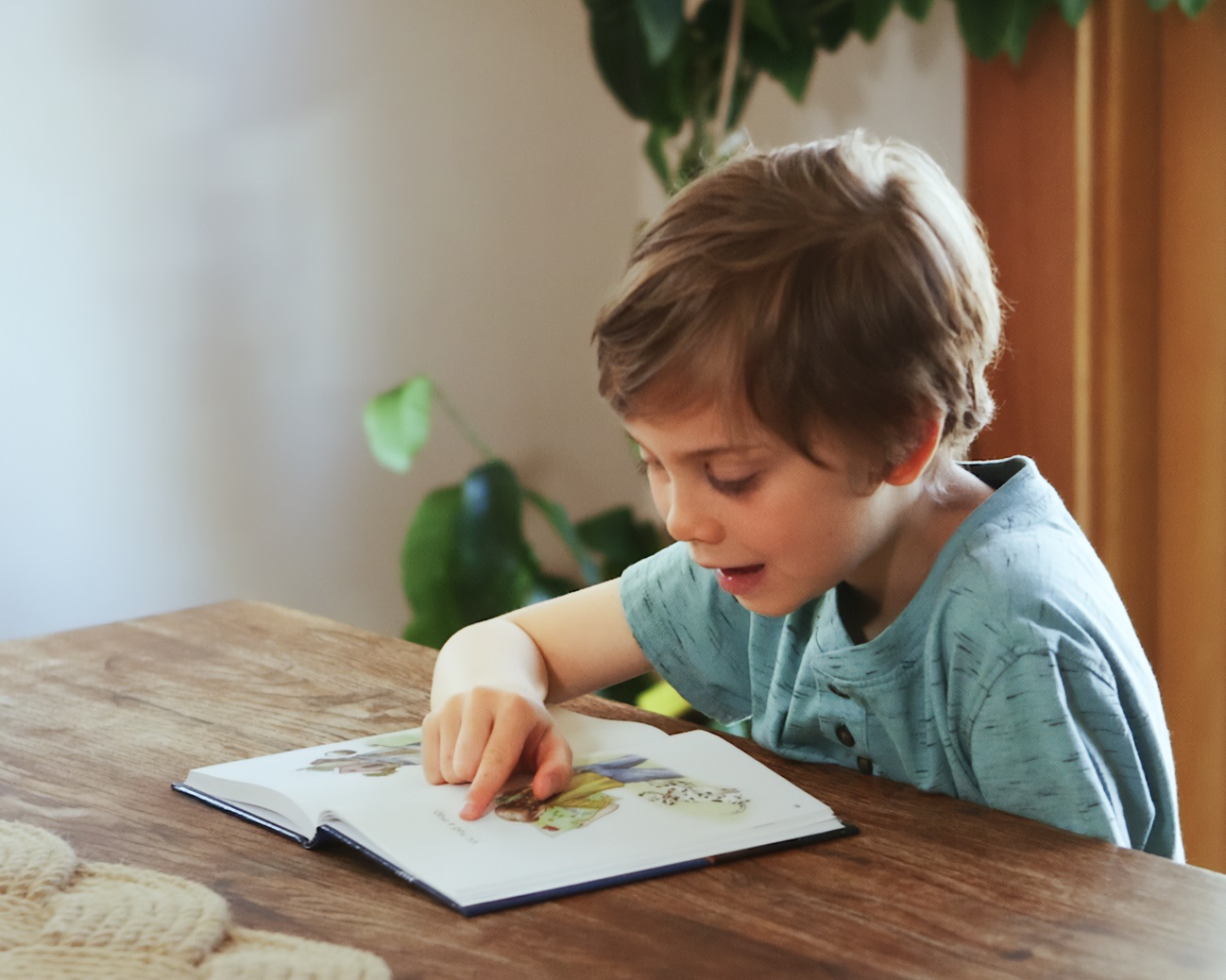 Young boy reading an All About Reading decodable reader