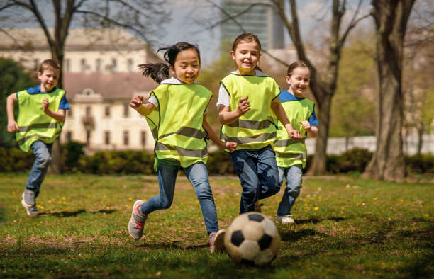 Children playing soccer outside.