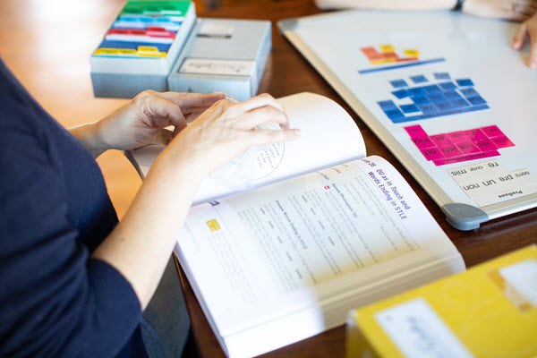 Parent reviewing a Teacher's Manual from All About Learning Press.